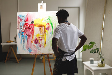 Wall Mural - African american male painter at work looking at artwork in art studio