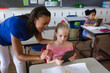 © WavebreakMediaMicro - African american female teacher teaching a girl to use digital tablet in class at elementary school
