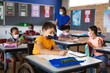© WavebreakMediaMicro - Disabled caucasian boy wearing face mask studying while sitting on wheelchair at elementary school