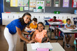 © WavebreakMediaMicro - Portrait of african american female teacher and disabled girl smiling in class at elementary school