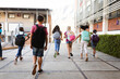 © WavebreakMediaMicro - Rear view of group of diverse students with backpacks running at elementary school