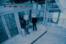 Security Camera Image Of Men Standing Outside Entrance Of Public Building