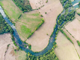 Canvas Print - Aerial shot of the river in between cultivated fields