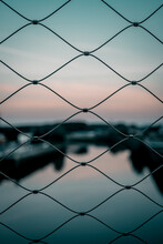 Close-up Of Chainlink Fence Against Sky During Sunset