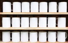 White mugs on wooden shelves. White mug mockup.