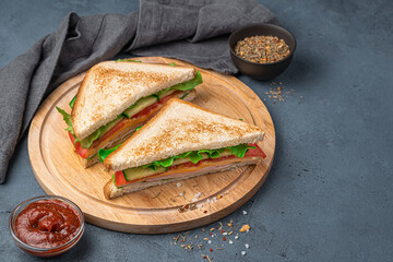 Two sandwiches with fried bread, ham, cheese and vegetables on a dark blue background. Side view, copy space