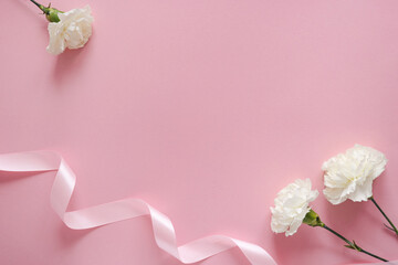 Wall Mural - Happy Mothers day. White flower with ribbon on a pink pastel background with copyspace