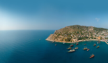 Wall Mural - Aerial wide view of Alanya Turkey, Summer morning. Travel and vacation. Ships and boats. Kızılkule bay. lighthouse and pier. Copy space Show program and entertainment for tourists, swimming