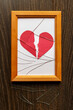 Paper heart torn to pieces, under glass shards in a photo frame