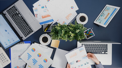 Poster - Top view of manager woman analyzing financial paperwork strategy typing expertise on laptop working in startup office. Businesswoman developing management accounting statistics braistorming ideas