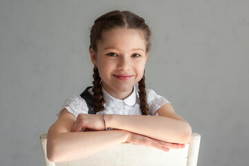 Wall Mural - Little schoolgirl sitting on chair