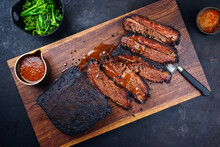 Modern Style Traditional Smoked Barbecue Wagyu Beef Brisket With Baby Broccoli Served As Top View On A Wooden Design Cutting Board With Louisiana Sauce