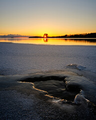 Wall Mural - sunset on the beach and snow in the foreground