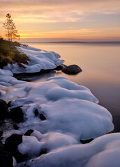 Wall Mural - sunrise over the lake with ice covered stones 