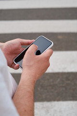 Wall Mural - man looks at a smartphone while crossing the road. the pedestrian does not follow the road rules. a 