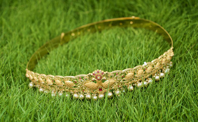 Wall Mural - Top view of a decorated golden bracelet on the green grass during Indian wedding