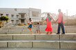 © Erin Brant/Stocksy - Joyous family marching on concrete steps