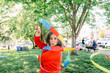 © ByLorena/Stocksy - Delighted mature woman playing with ribbon in park
