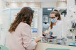 © Mal de Ojo Studio/Stocksy - Woman wearing face mask shopping for glasses
