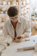 © Ivan Ozerov/Stocksy - Young woman creating clay cup in pottery