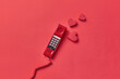 © Yaroslav Danylchenko/Stocksy - Vitage red telephone handset with hearts