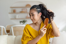 Asian Woman Using A Hairbrush