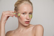 © Anna Tabakova/Stocksy - Model with green jade roller and under-eye patch