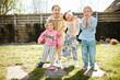 © Melissa Milis Photography/Stocksy - Group portrait of 4 siblings making funny faces