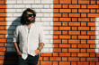 © Olga Moreira/Stocksy - Portrait of a bearded man against brick wall