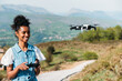 © David Prado/Stocksy - Black woman controlling drone flying in nature