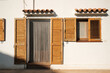 © Malquerida Studio/Stocksy - Old wooden shutters on a white Mediterranean facade