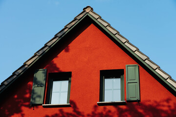 Poster - Closeup shot of a house with red walls on a clear sky background