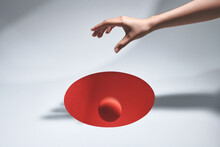 Female Hand Dropping Ball In To The Hole On White Table