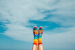 © Juan Moyano/Stocksy - rainbow patterned socks and sandals against the sky