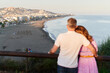 © Ivan Gener/Stocksy - Loving couple looking a view of the beach