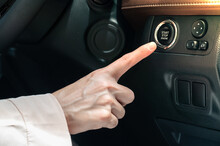 Close up of someone trying to ignition car by push start button. Push button start is designed to work similarly to using a traditional key ignition.