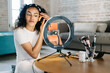 © Javier Díez/Stocksy - Beauty blogger applying makeup on cheek