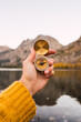 © Kike Arnaiz/Stocksy - Unrecognizable person holding a compass besides a lake
