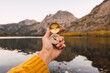 © Kike Arnaiz/Stocksy - Unrecognizable person holding a compass besides a lake