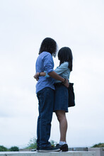 Young Couple Hugging On Top Of Wall Looking At City 