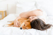 © Olga Sibirskaya/Stocksy - Woman cuddle dog in bed