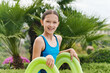 © Ivan Gener/Stocksy - Smiling little girl standing on a pool slide