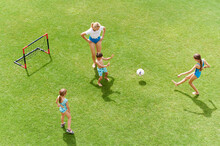 Mom And Kids Playing Soccer Outside