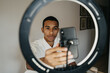 © Alba Vitta/Stocksy - Young man doing beauty routine video tutorial at home
