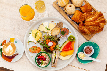 Sticker - Top view of croissants, different pastries with a cup of latte and orange juice with other snacks