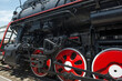 Eliminations of an old Russian steam locomotive. Black steam locomotive, red wheels.