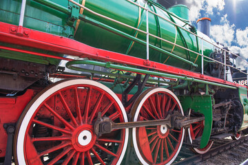 Eliminations of an old Russian steam locomotive. Black steam locomotive, red wheels.