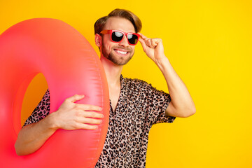 Poster - Photo of confident sweet gentleman dressed print shirt arm dark glasses holding swim circle empty space isolated yellow color background