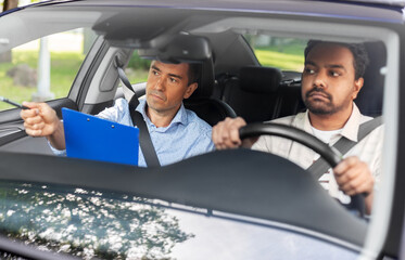 Wall Mural - driver courses, exam and people concept - young man and driving school instructor with clipboard in car