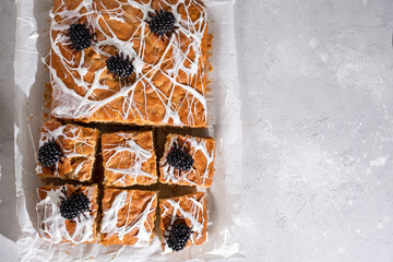 Wall Mural - Halloween decorated food. Banana bread cake bars with halloween marshmallow web and funny blackberry spiders